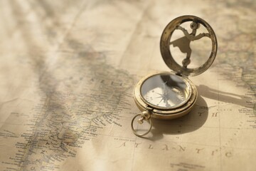 Retro style antique golden compass (sundial) and old nautical chart close-up. Vintage still life....