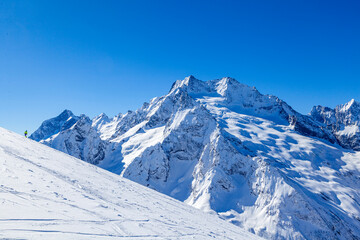 Caucasus Mountains, Panoramic view of the ski slope  on the horizon in winter day. Dombai ski resort, Western Caucasus, Karachai-Cherkess, Russia.