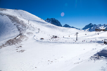 Fototapeta na wymiar Caucasus Mountains, Panoramic view of the ski slope on the horizon in winter day. Dombai ski resort, Western Caucasus, Karachai-Cherkess, Russia.
