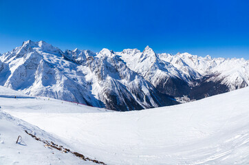 Caucasus Mountains, Panoramic view of the ski slope on the horizon in winter day. Dombai ski resort, Western Caucasus, Karachai-Cherkess, Russia. View of Mount Elbrus