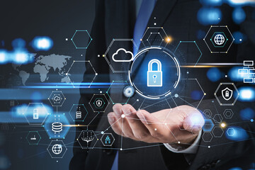 Businessman holding hologram padlock on palm, blue glowing information protection icons. Cloud and digital interface. Concept of cyber security.