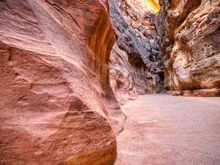 Picture with al-Siq, the natural passage through red rock walls which is main entrance to the ancient Nabatean city of Petra in southern Jordan.