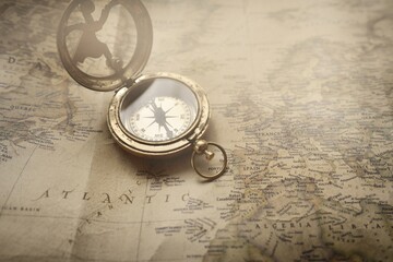 Retro style antique golden compass (sundial) and old nautical chart close-up. Vintage still life....