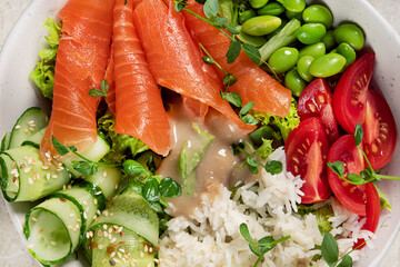 Poke bowl with salmon, cucumber, tomato, rice and edamame beans
