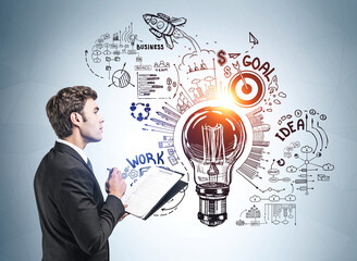 Businessman in formal suit takes notes and stands near sketch