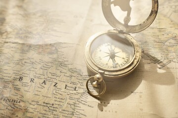 Retro style antique golden compass (sundial) and old nautical chart close-up. Vintage still life. Sailing accessories. Wanderlust, travel and navigation theme. Graphic resources, copy space