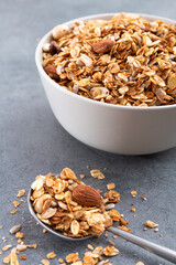 Fresh granola with almonds in a white bowl.