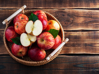 Fresh organic apples in a basket on a wooden background. Sliced. Rustic. New Zealand gala variety. Copy space.