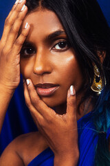 portrait of dark skinned Indian woman from Malaysia against a dark blue background