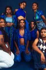Tuinposter group portraits of dark skinned Indian women from Malaysia against a dark blue background © Daniel Adams