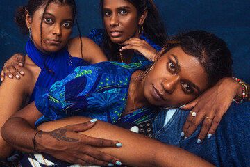 group portraits of dark skinned Indian women from Malaysia against a dark blue background