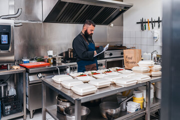 Food in disposable dishes ready for delivery. The chef prepares food in the restaurant and packs it in disposable lunch boxes.
