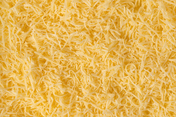 Grated cheese background texture. yellow shredded  cheese. Close up top view.