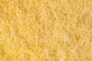 Grated cheese background texture. yellow shredded  cheese. Close up top view.