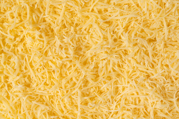 Grated cheese background texture. yellow shredded  cheese. Close up top view.