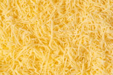 Grated cheese background texture. yellow shredded  cheese. Close up top view.