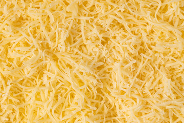Grated cheese background texture. yellow shredded  cheese. Close up top view.