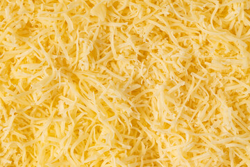 Grated cheese background texture. yellow shredded  cheese. Close up top view.