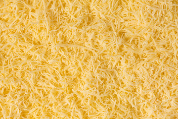 Grated cheese background texture. yellow shredded  cheese. Close up top view.