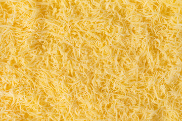 Grated cheese background texture. yellow shredded  cheese. Close up top view.