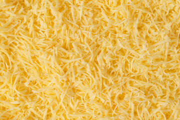 Grated cheese background texture. yellow shredded  cheese. Close up top view.