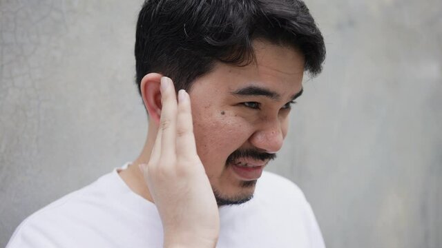 slow motion scene adult middle eastern man use hand massage on ear after feeling pain form eardrum syndrome for unhealthy lifestyle concept