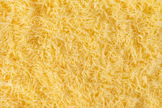 Grated cheese background texture. yellow shredded  cheese. Close up top view.