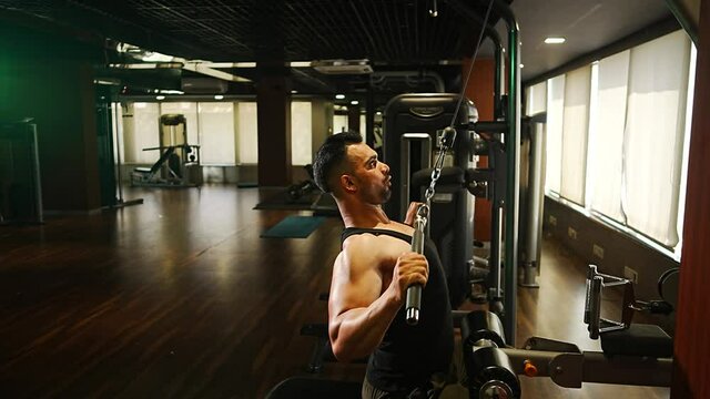 professional athlete bodybuilder working out in the indoor gym. weight lifting and bodybuilding, muscle strengthening workout. man doing exercise on machine for fitness. back training on lat pull down