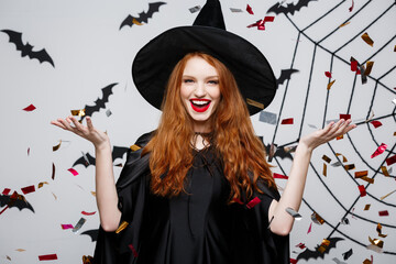 Halloween Witch Concept - Happy elegant witch throwing confetti for celebrating halloween party...
