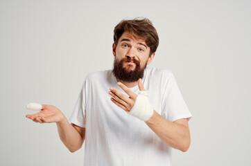 bearded man bandaged hand injury to fingers hospitalization isolated background