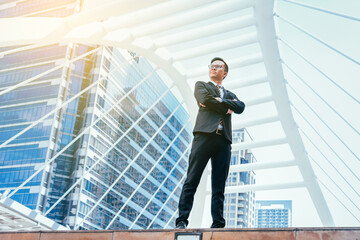 Young businessman handsome who standing in feeling commitment to doing business with cityscape background.