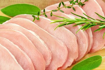 Fresh pork meat 10 steaks on wooden board with herbs