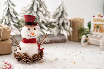 Snowman Christmas decoration with gift boxes and fir tree on white background. Copy space.