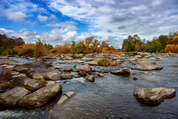 Fototapeta na wymiar Autumn river with beautiful large stones, blue sky and trees
