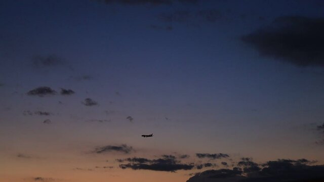 夕暮れの空を飛ぶ飛行機