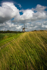 Fototapeta na wymiar Typical dutch windmill with cloudy sky