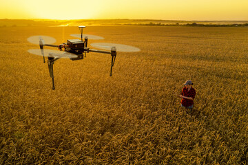 Woman farmer controls drone with a tablet. Smart farming and precision agriculture	
