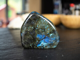 Labradorite mineral stone on slate worktop.