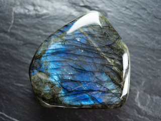 Labradorite mineral stone on slate worktop. Flat lay, top view.
