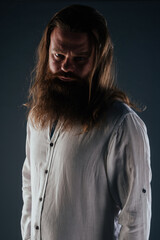Close up portrait of handsome manly guy with beard posing in studio on a isolated background.