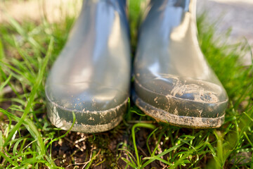 Schmutzige Gummistiefel im Gras