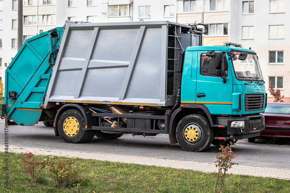 Poster a garbage truck picks up garbage in a residential area. separate collection and disposal of garbage.