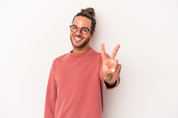 Fototapeta premium Young caucasian man isolated on white background joyful and carefree showing a peace symbol with fingers.