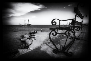 A pleasure boat and bench in the harbor