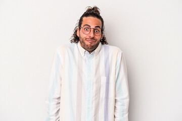 Young caucasian man isolated on gray background shrugs shoulders and open eyes confused.