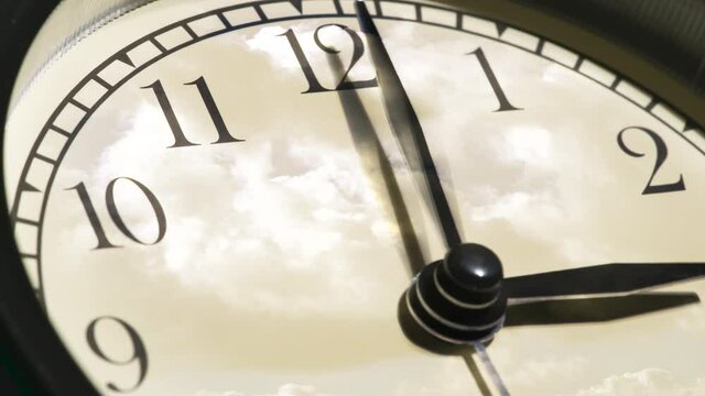 Contemplating the Flow of Time. Time laps. On the light dial of the watch, the hands rotate quickly and the sky with beautiful seething clouds is reflected