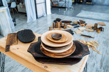 A set of wooden utensils. A mountain of plates in the carpentry workshop. handmade wood products by a carpenter.