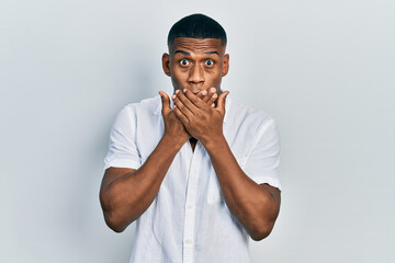Young black man wearing casual white shirt shocked covering mouth with hands for mistake. secret concept.