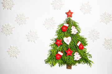 Christmas Tree made of thuja branches and wooden decorations on white background, top view. Holiday Concept. Flat Lay