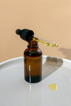 dark glass cosmetic bottle with a dropper on a cramic background. Natural cosmetics concept, natural essential oil and skin care products
